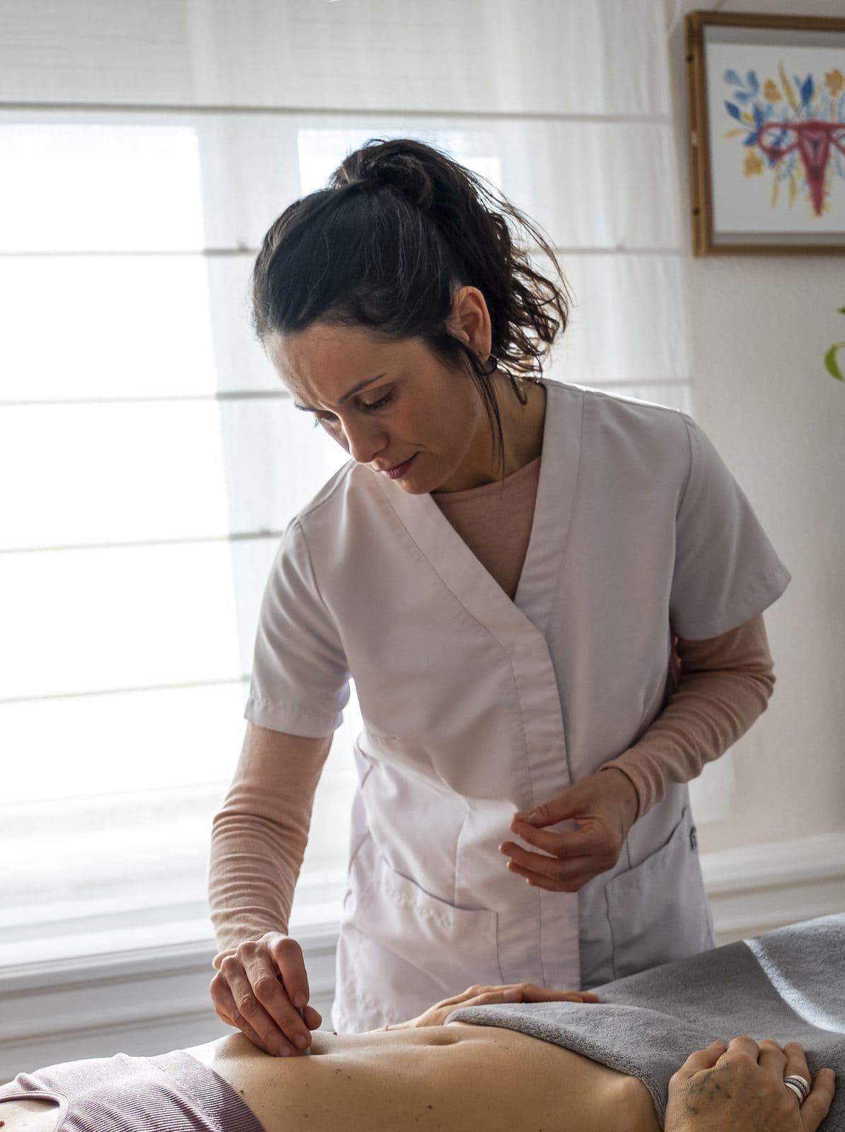 Marta Heredia aplicando acupuntura en el abdomen en su consulta de Barcelona